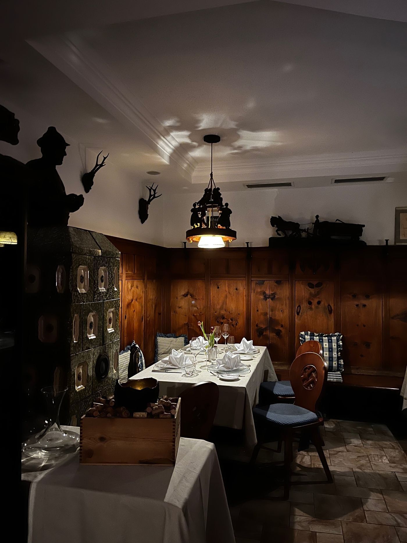 Gedeckter Tisch in der historischen Zirmstube mit Holzvertäfelung und Kachelofen