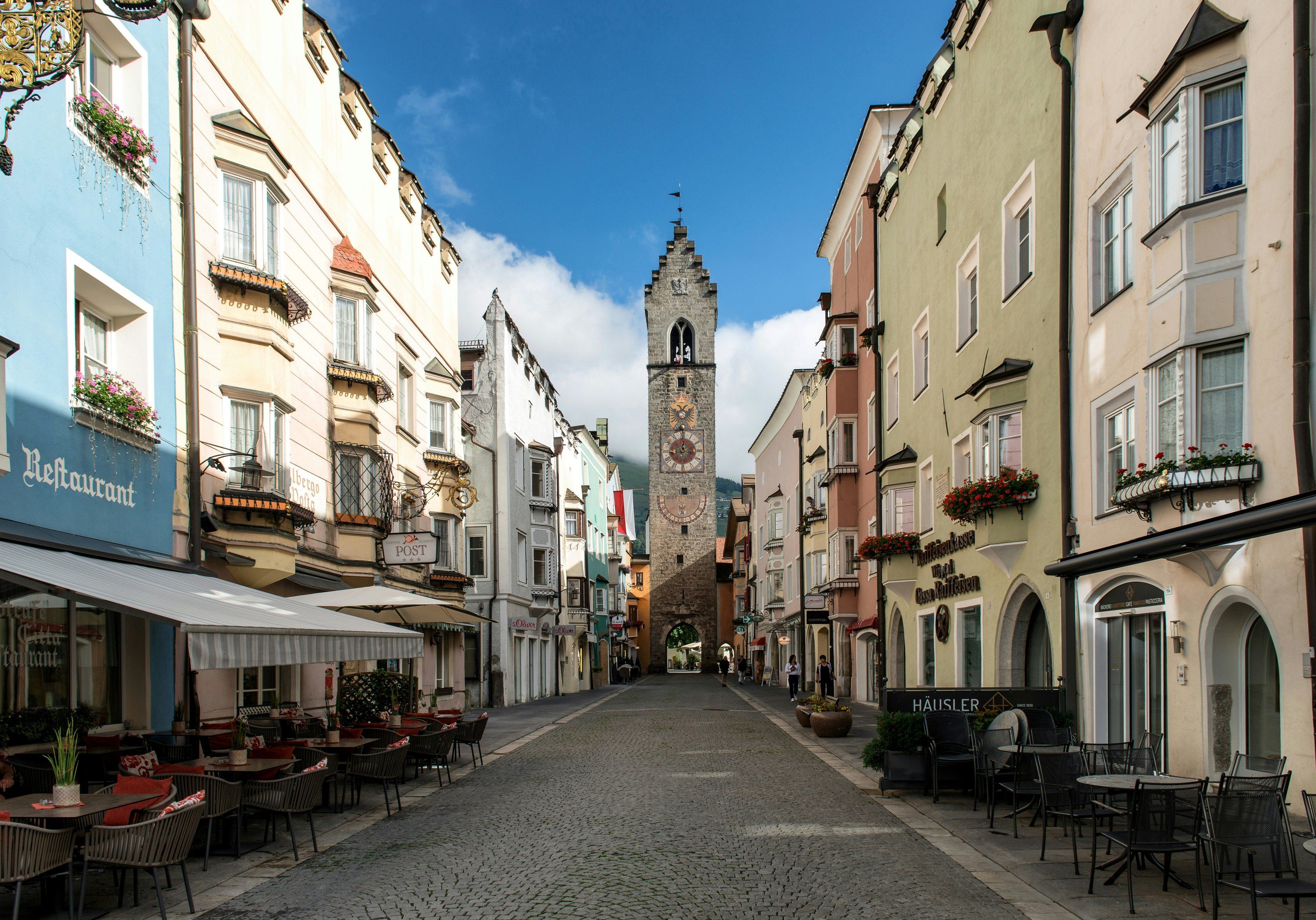 Die Sterzinger Altstadt mit farbigen Erkerhäusern und dem Zwölferturm am Ende der Gasse